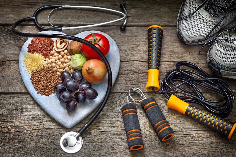 Work out equipment and healthy food on a heart shaped platter.